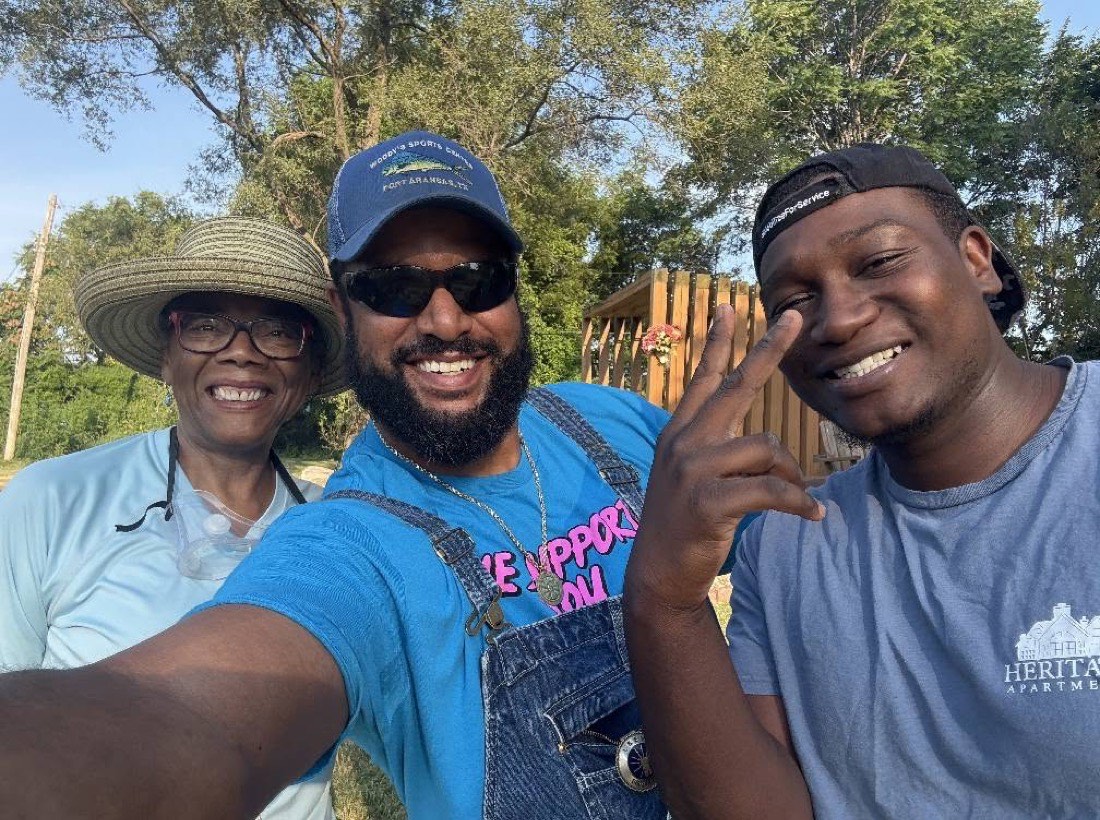 Three volunteers smiling at a service event